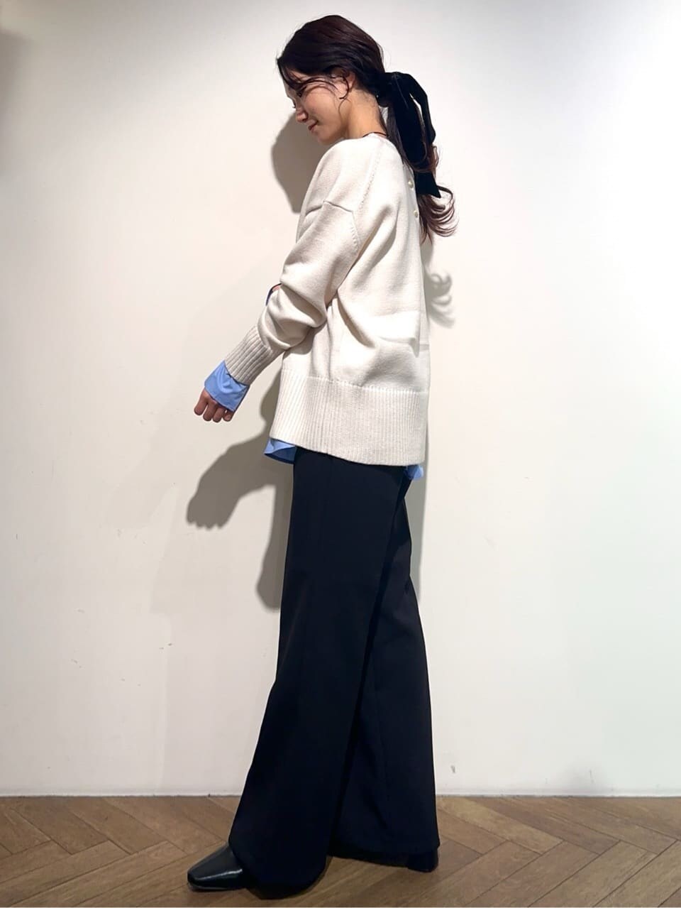 ホワイト系のニット/セーター、ブルー系のTシャツ/カットソー、ブラック系のその他パンツを着用したレディースの冬コーディネートの2枚目の写真