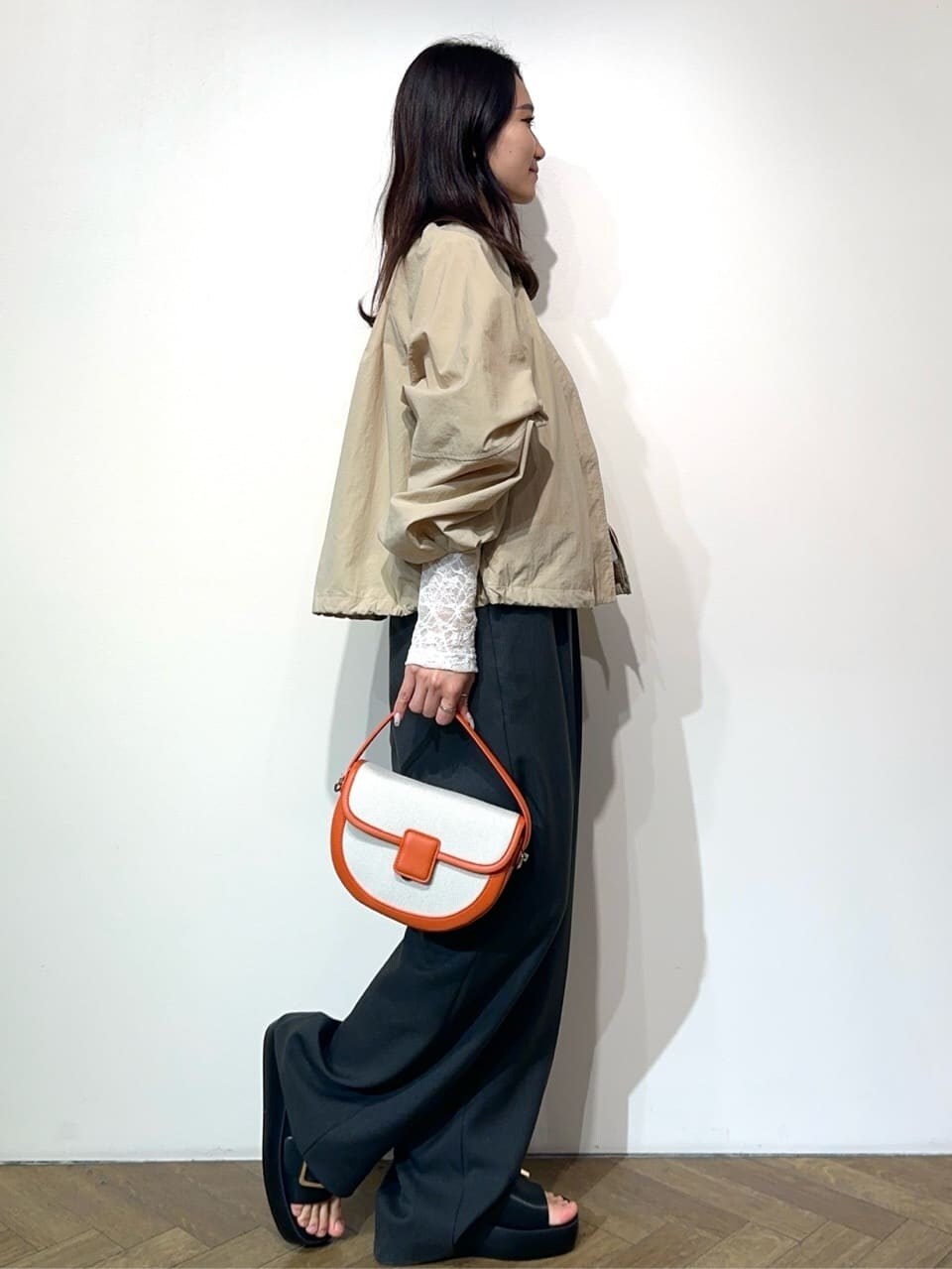 ベージュ系のノーカラーコート、ホワイト系のTシャツ/カットソー、グレー系のサロペット/オーバーオールを着用したレディースの春コーディネートの5枚目の写真