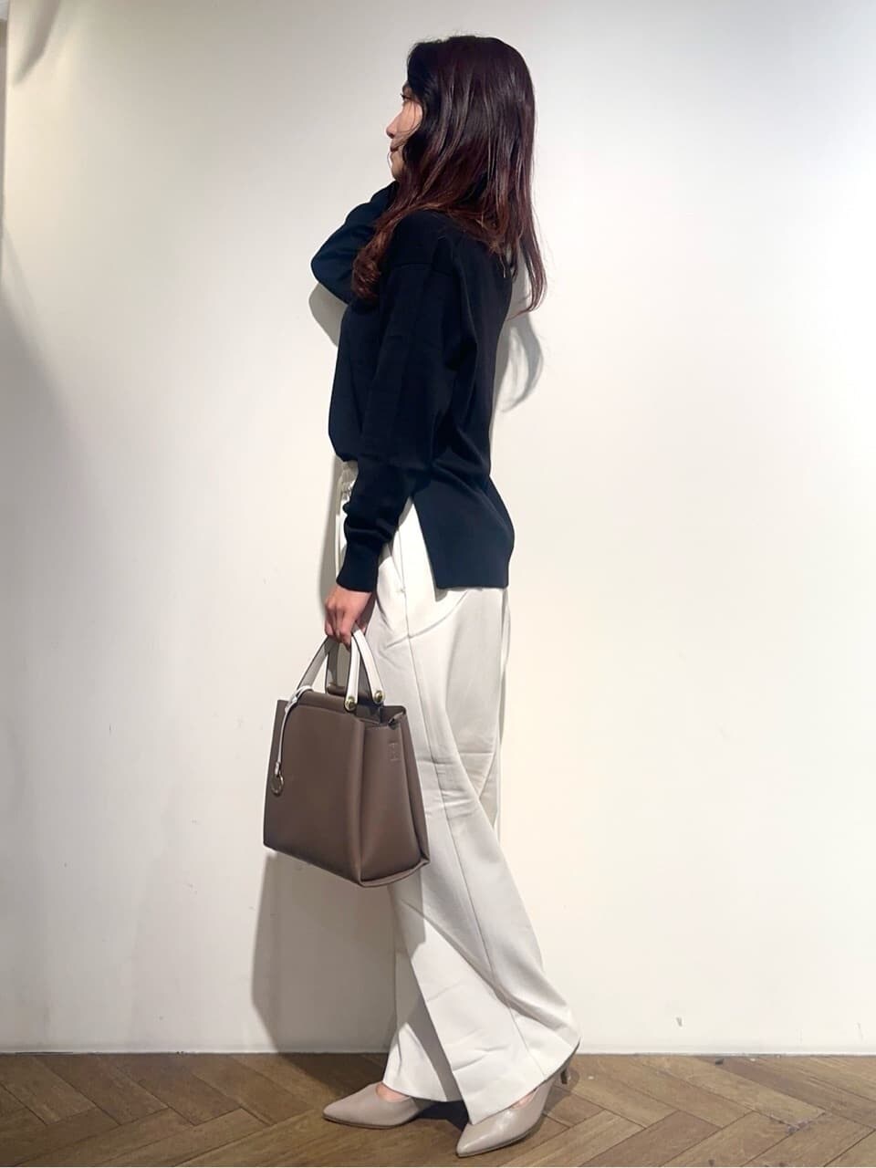 イエロー系のノーカラージャケット、ブラック系のニット/セーター、ホワイト系のその他パンツを着用したレディースの秋コーディネートの7枚目の写真