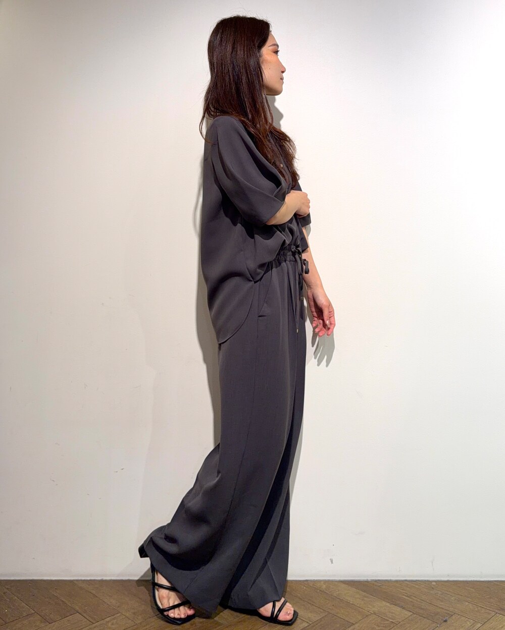 グレー系のシャツ/ブラウス、グレー系のその他パンツ、ブラック系のサンダルを着用したレディースの春コーディネートの4枚目の写真