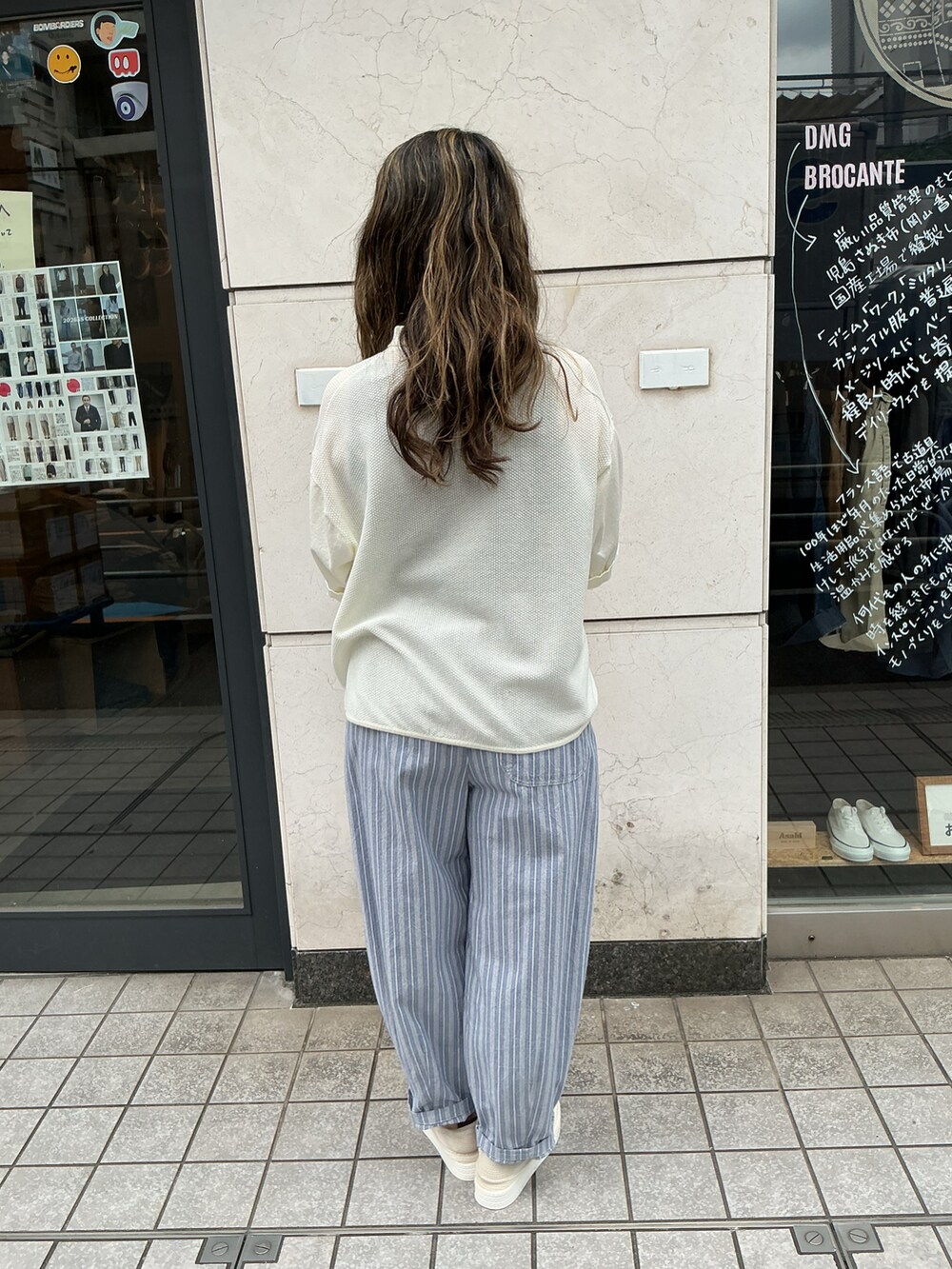 ホワイト系のニット/セーター、ブルー系のパンツ、ブルー系のバッグを着用したレディースの夏コーディネートの4枚目の写真