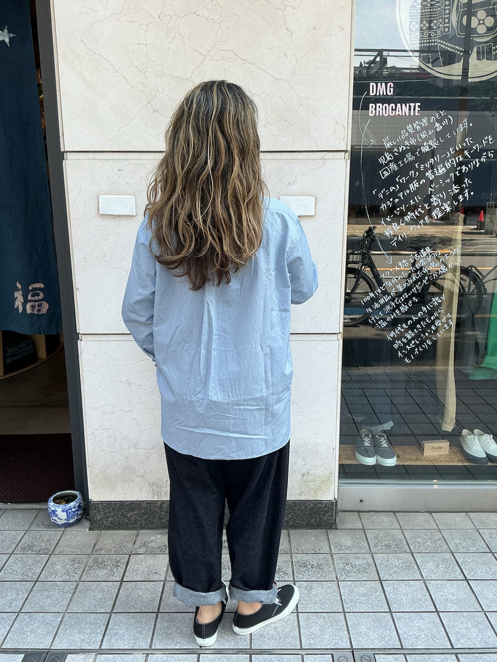 ブルー系のシャツ/ブラウス、ブルー系のデニムパンツ、ブラック系のスニーカーを着用したレディースの秋コーディネートの3枚目の写真