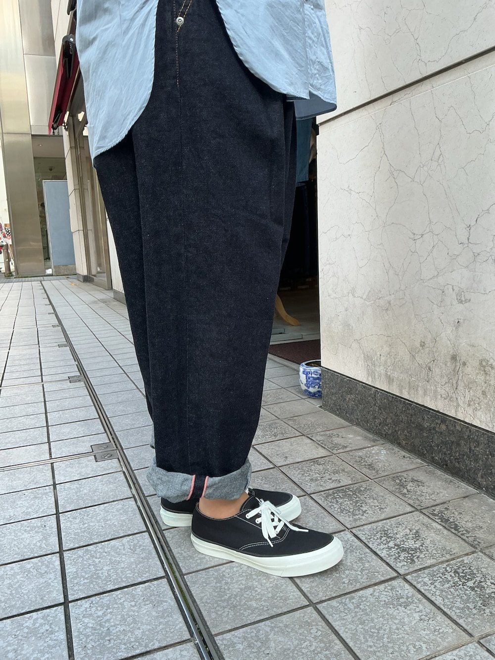 ブルー系のシャツ/ブラウス、ブルー系のデニムパンツ、ブラック系のスニーカーを着用したレディースの秋コーディネートの5枚目の写真