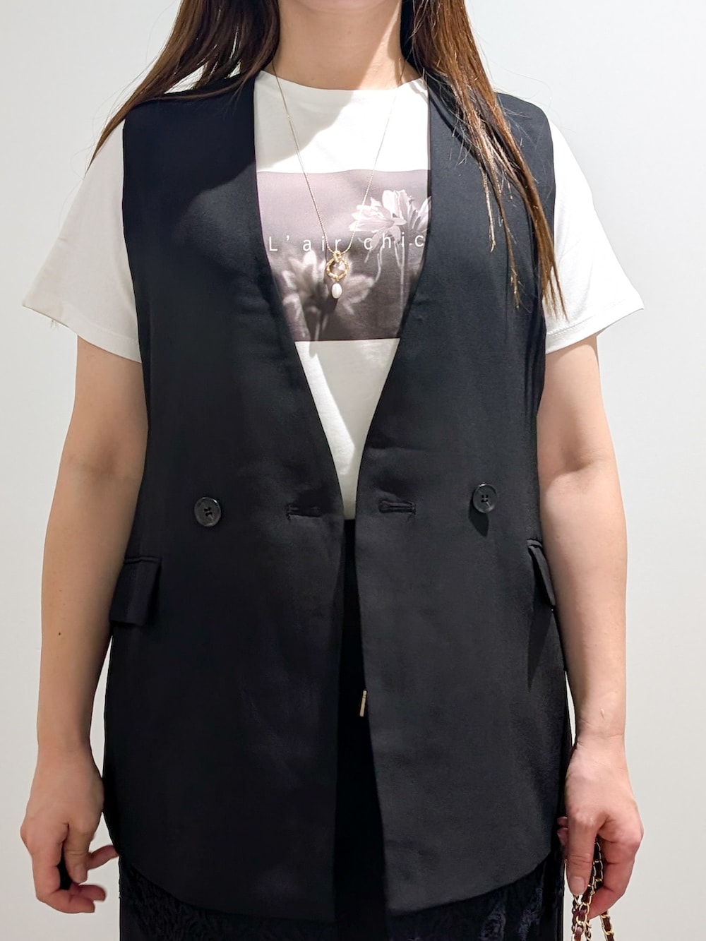 ブラック系のベスト、ホワイト系のTシャツ/カットソー、ブラック系のその他パンツを着用したレディースの秋コーディネートの6枚目の写真