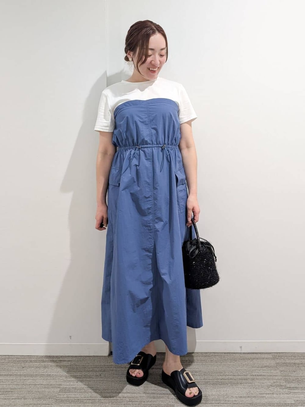 ブルー系のワンピース、ブラック系のハンドバッグ、ブラック系のサンダルを着用したレディースの夏コーディネートの9枚目の写真