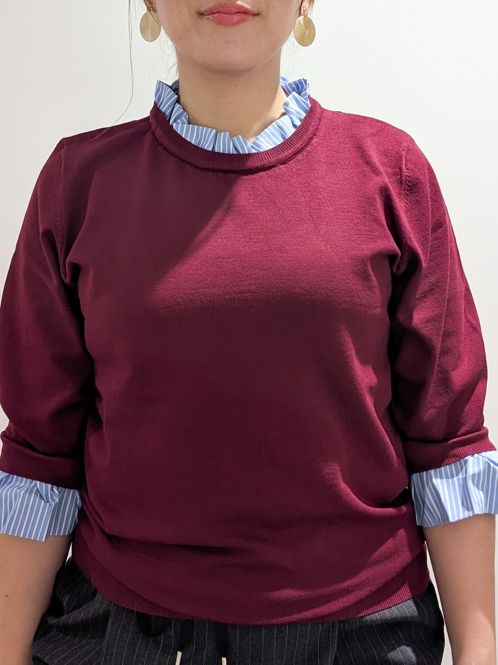 レッド系のニット/セーター、グレー系のその他パンツ、ブラック系のトートバッグを着用したレディースの秋コーディネートの5枚目の写真