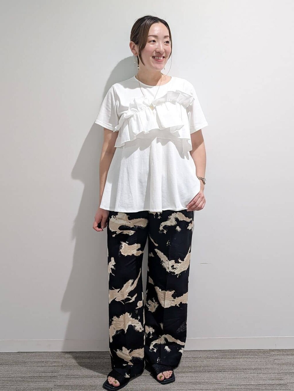 ホワイト系のTシャツ/カットソー、ブラック系のその他パンツ、ブラック系のサンダルを着用したレディースの夏コーディネートの2枚目の写真
