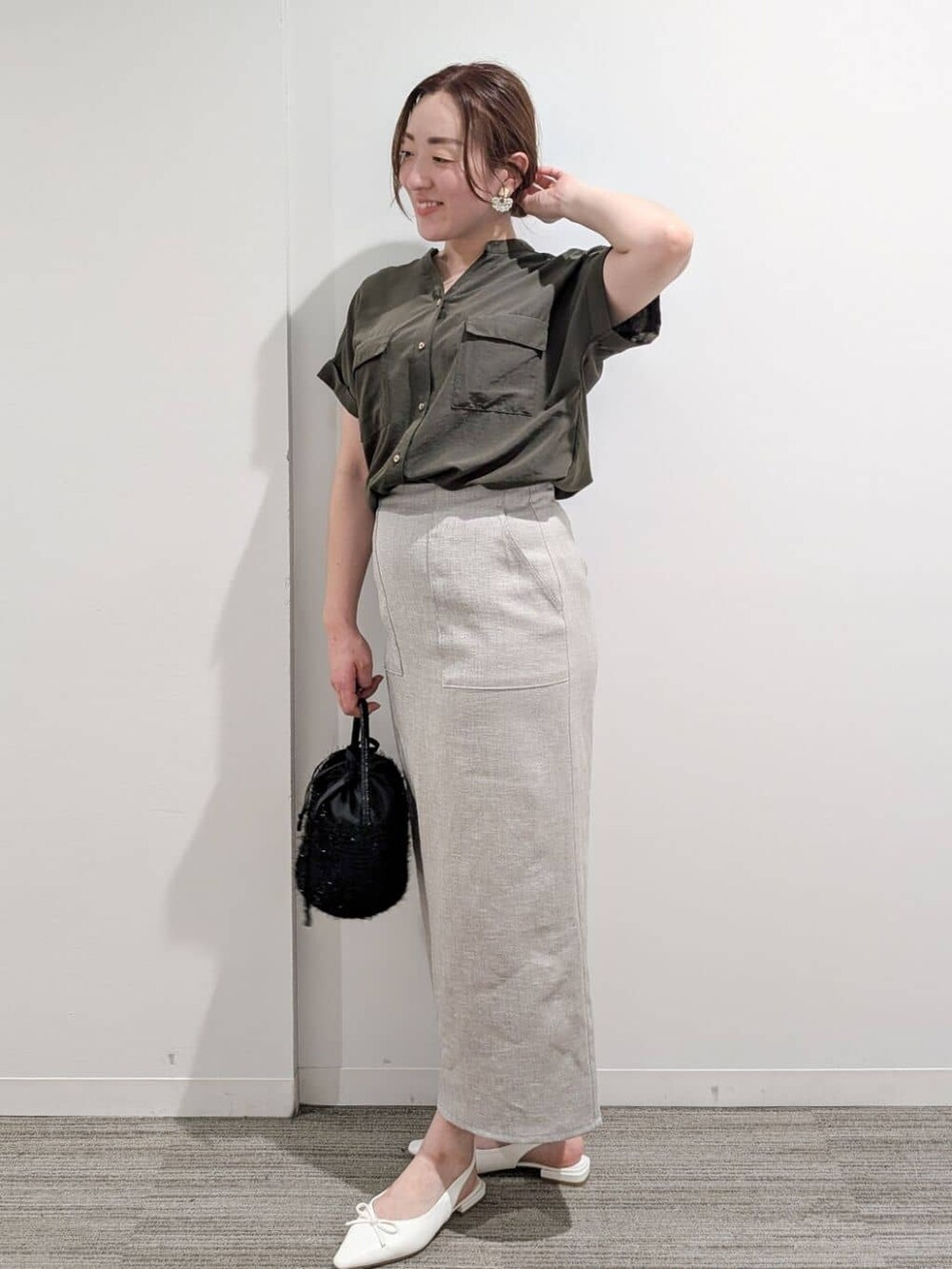 グリーン系のシャツ/ブラウス、ベージュ系のスカート、ブラック系のハンドバッグを着用したレディースの夏コーディネートの4枚目の写真
