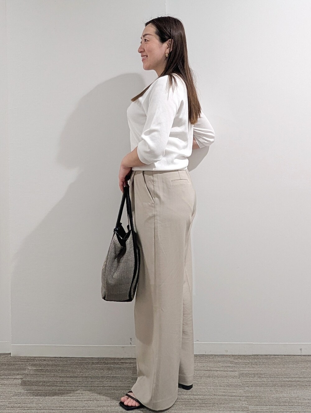 ホワイト系のニット/セーター、ベージュ系のその他パンツ、グレー系のトートバッグを着用したレディースの春コーディネートの8枚目の写真