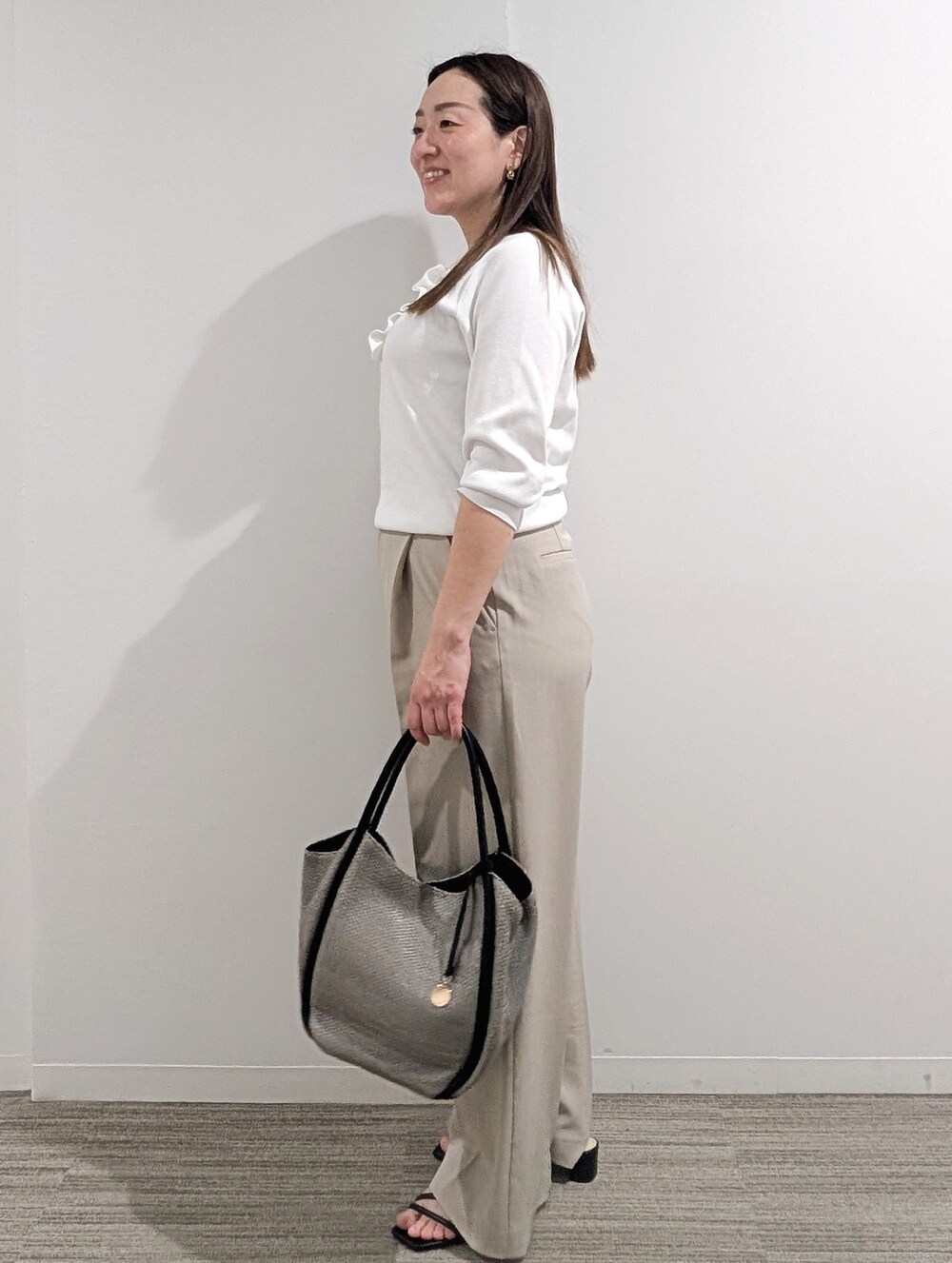 ホワイト系のニット/セーター、ベージュ系のその他パンツ、グレー系のトートバッグを着用したレディースの春コーディネートの9枚目の写真