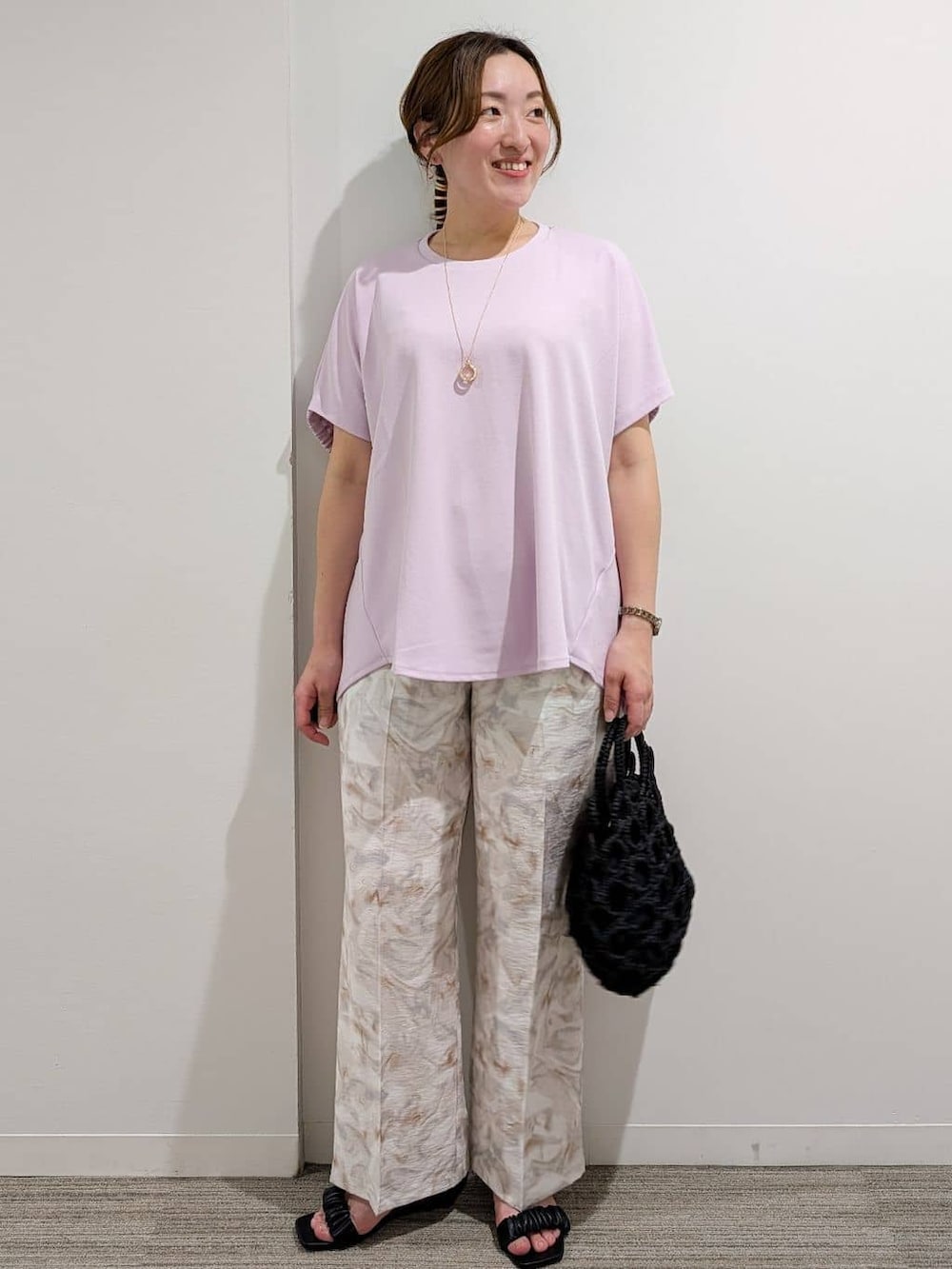 ピンク系のTシャツ/カットソー、グレー系のその他パンツ、ブラック系のハンドバッグを着用したレディースの夏コーディネートの5枚目の写真