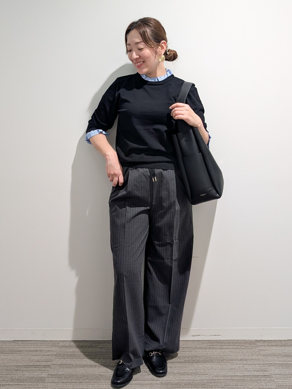 ブラック系のニット/セーター、グレー系のその他パンツ、ブラック系のトートバッグを着用したレディースの秋コーディネートの8枚目の写真