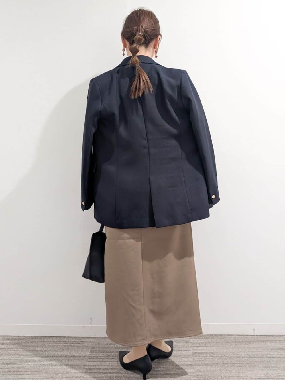 ブルー系のシャツ/ブラウス、ブラック系のパンプス、ブラウン系のスカートを着用したレディースの春コーディネートの5枚目の写真