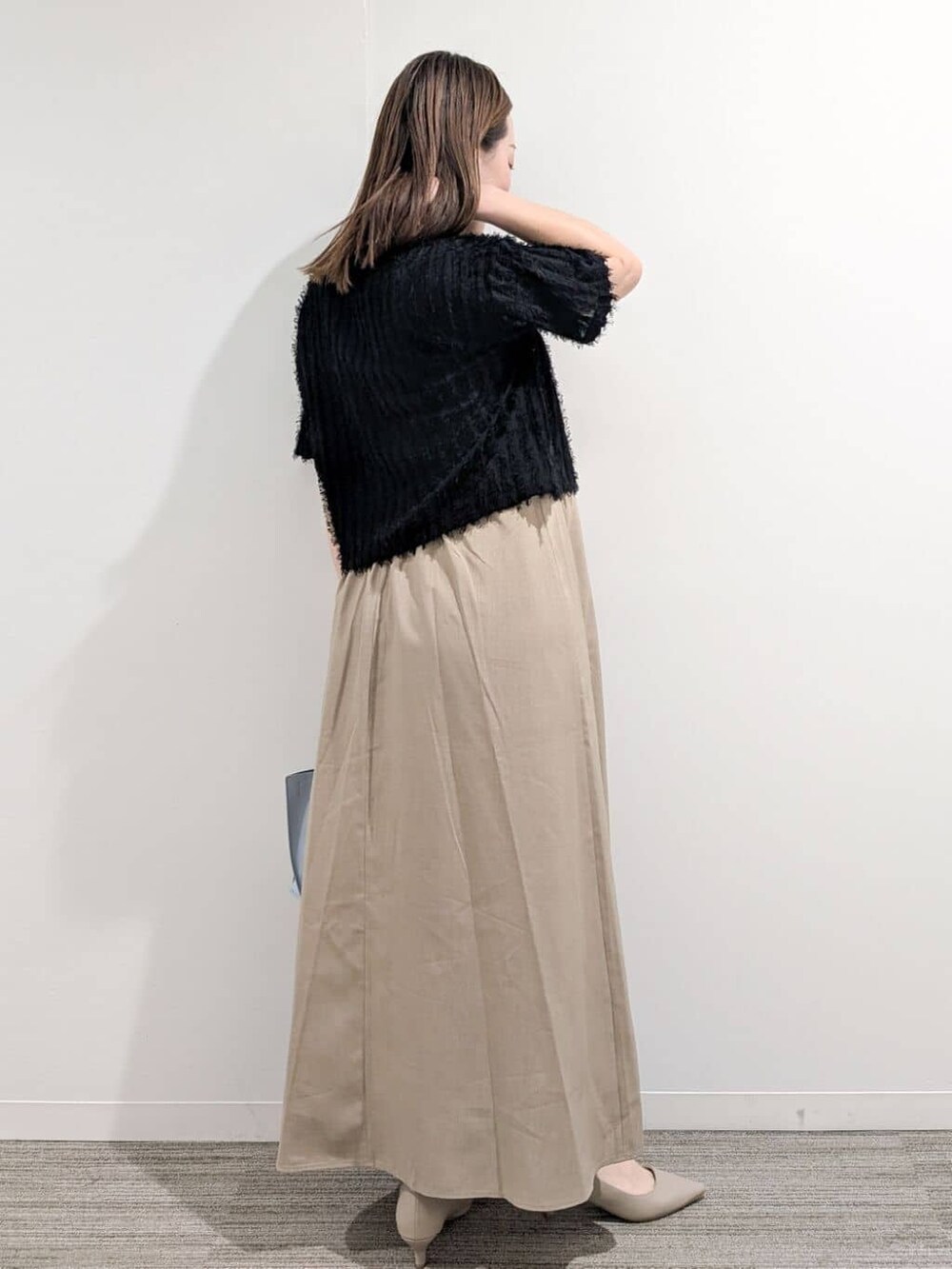 ブラック系のニット/セーター、ベージュ系のワンピース、ブルー系のトートバッグを着用したレディースの夏コーディネートの6枚目の写真