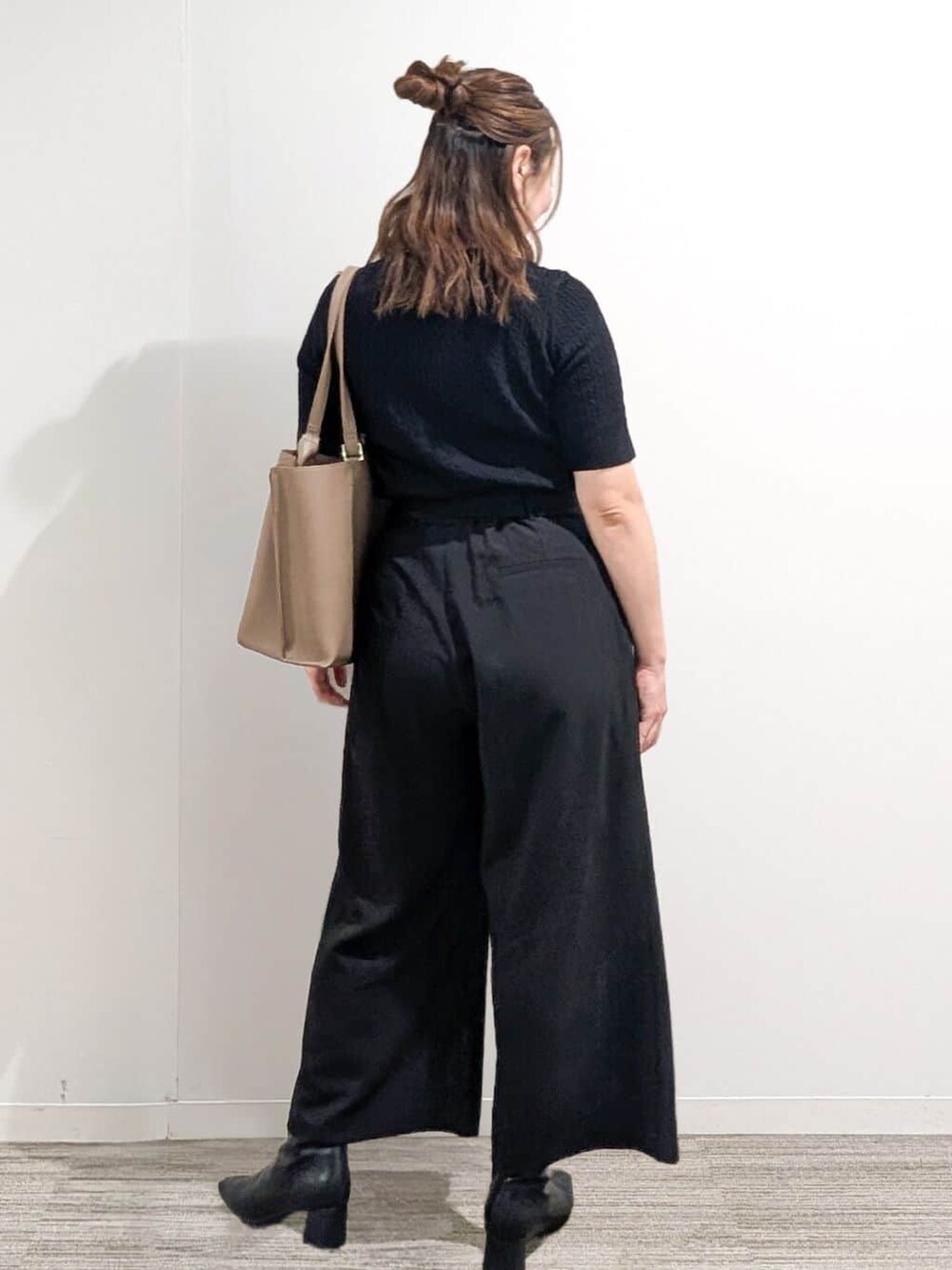 ブラック系のニット/セーター、ブラック系のその他パンツ、ベージュ系のトートバッグを着用したレディースの秋コーディネートの3枚目の写真