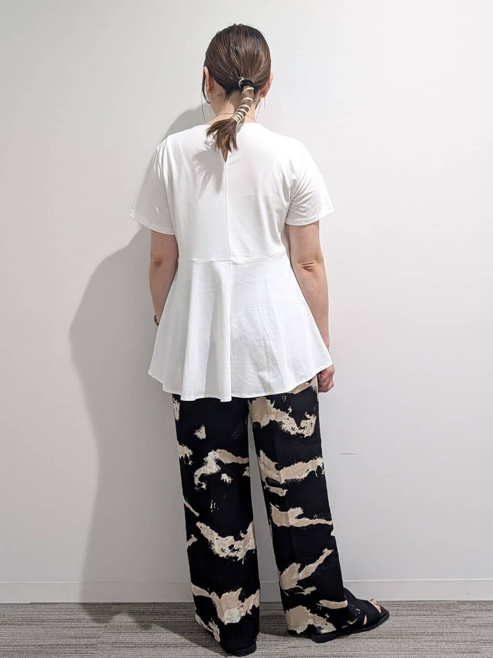 ホワイト系のTシャツ/カットソー、ブラック系のその他パンツ、ブラック系のサンダルを着用したレディースの夏コーディネートの7枚目の写真