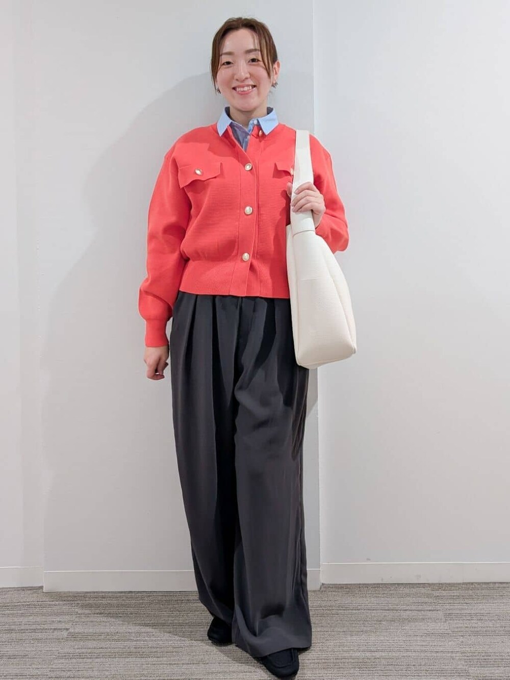 オレンジ系のカーディガン/ボレロ、ブルー系のシャツ/ブラウス、グレー系のその他パンツを着用したレディースの冬コーディネートの2枚目の写真