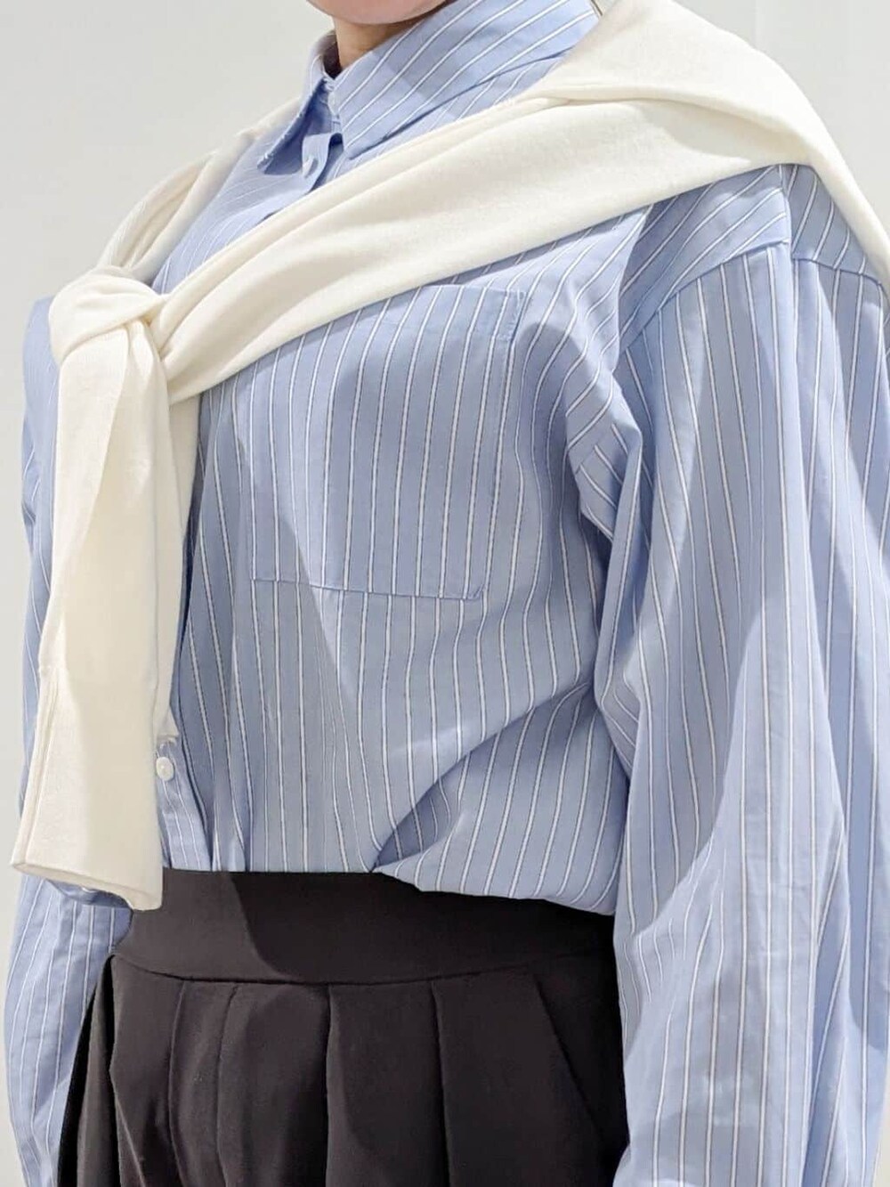 ブルー系のシャツ/ブラウス、ホワイト系のニット/セーター、グレー系のその他パンツを着用したレディースの冬コーディネートの6枚目の写真