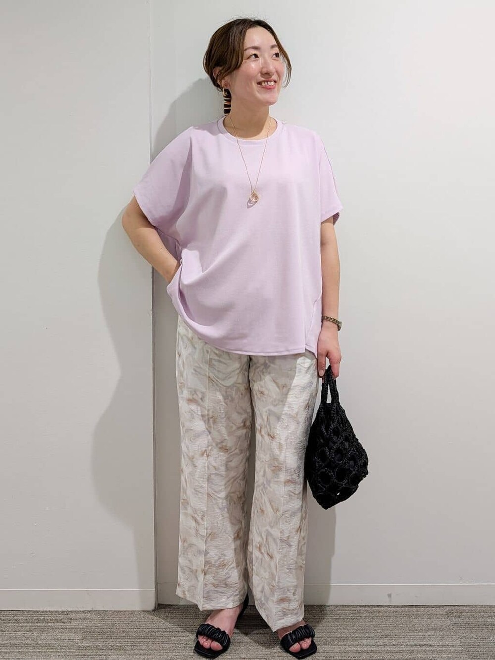 ピンク系のTシャツ/カットソー、グレー系のその他パンツ、ブラック系のハンドバッグを着用したレディースの夏コーディネートの6枚目の写真