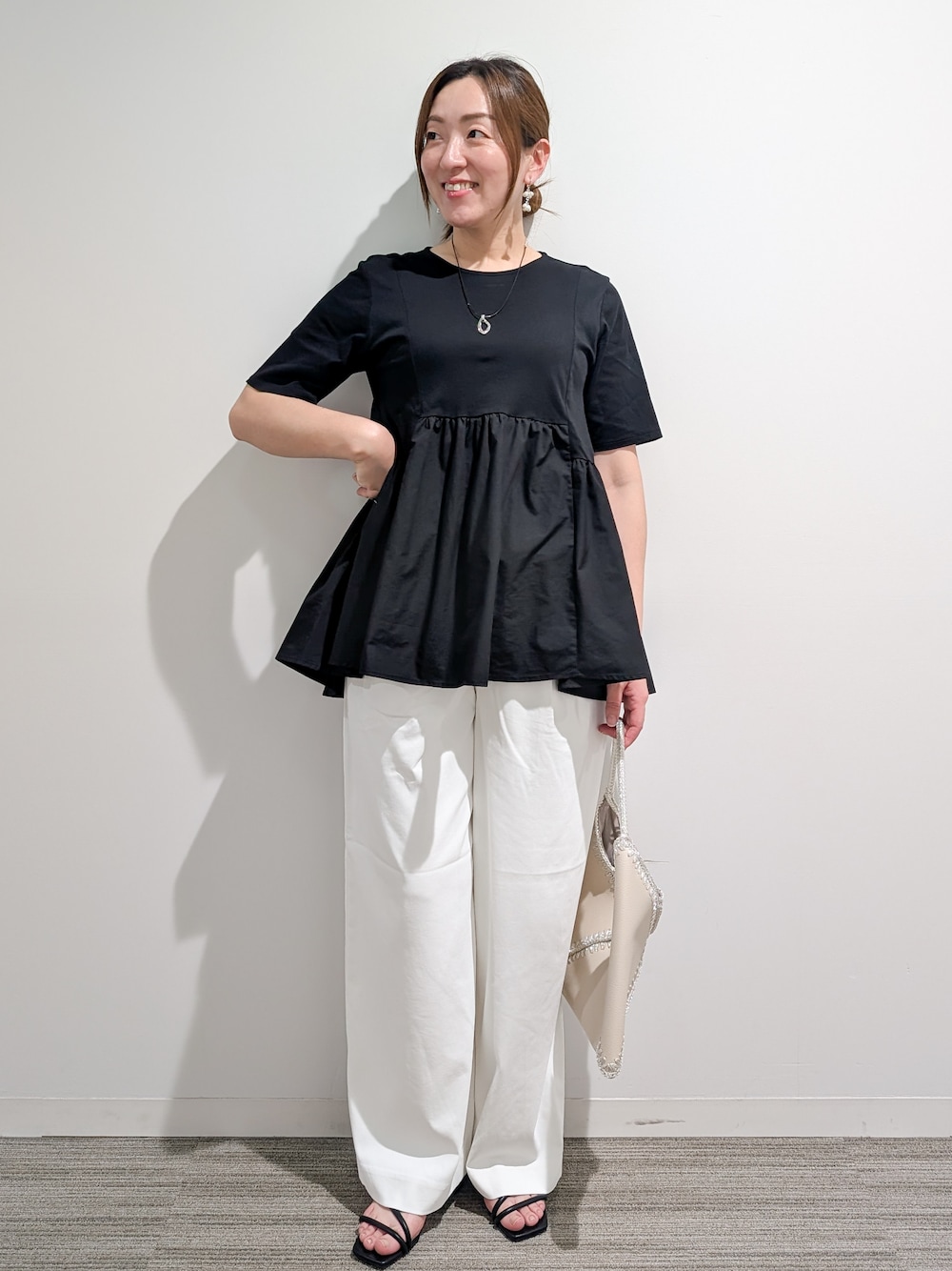 ブラック系のTシャツ/カットソー、ホワイト系のその他パンツ、ホワイト系のハンドバッグを着用したレディースの夏コーディネートの6枚目の写真