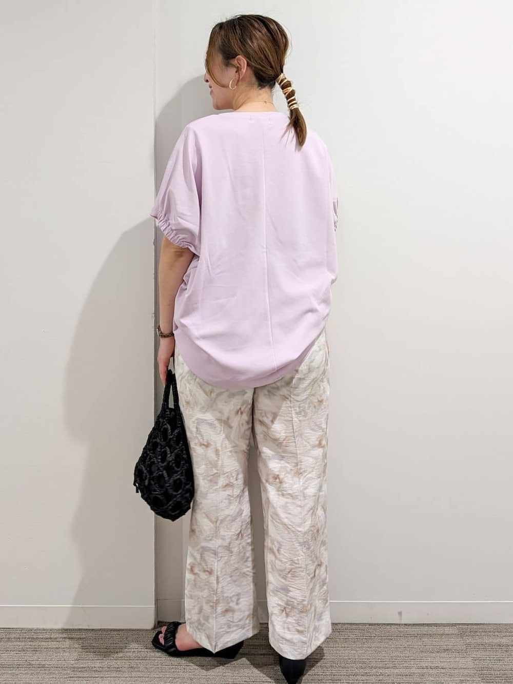ピンク系のTシャツ/カットソー、グレー系のその他パンツ、ブラック系のハンドバッグを着用したレディースの夏コーディネートの3枚目の写真