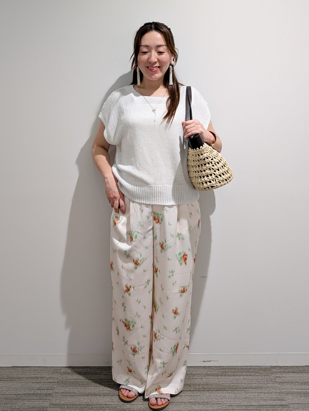 ホワイト系のニット/セーター、ホワイト系のその他パンツ、ブラウン系のトートバッグを着用したレディースの夏コーディネートの3枚目の写真