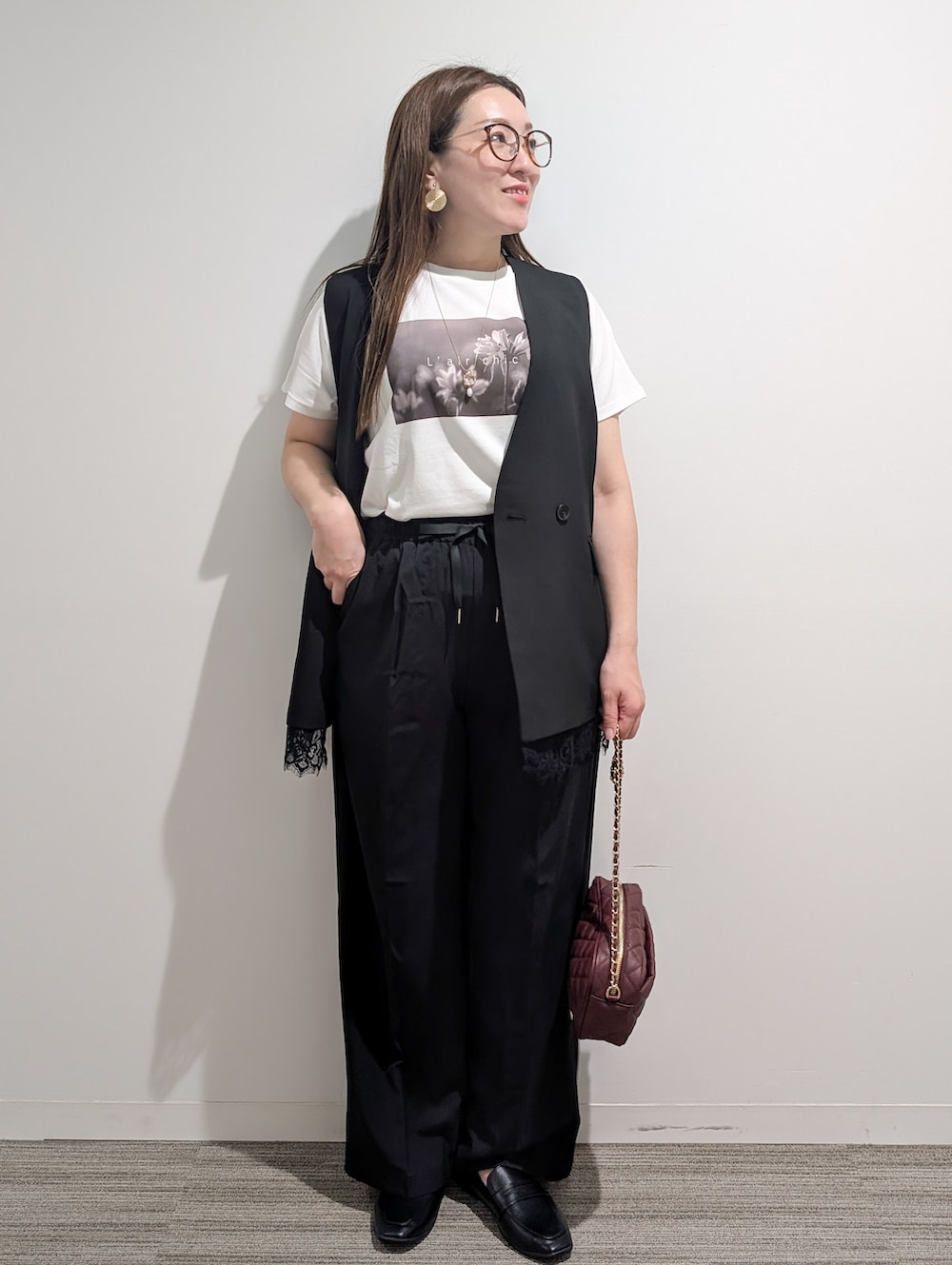 ブラック系のベスト、ホワイト系のTシャツ/カットソー、ブラック系のその他パンツを着用したレディースの秋コーディネートの9枚目の写真