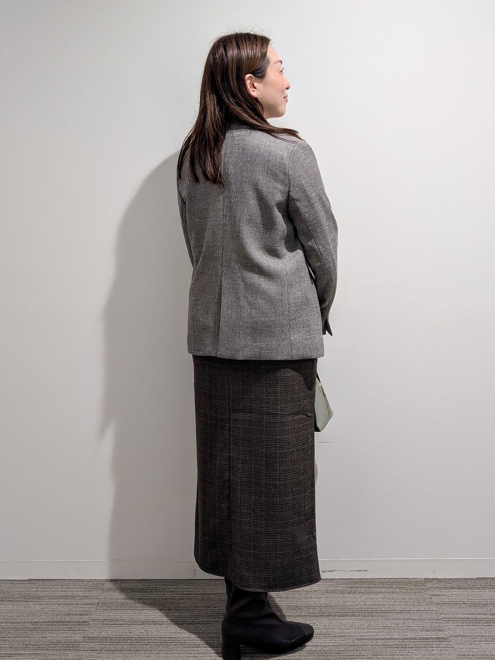 グレー系のノーカラージャケット、レッド系のニット/セーター、ブラウン系のスカートを着用したレディースの秋コーディネートの6枚目の写真