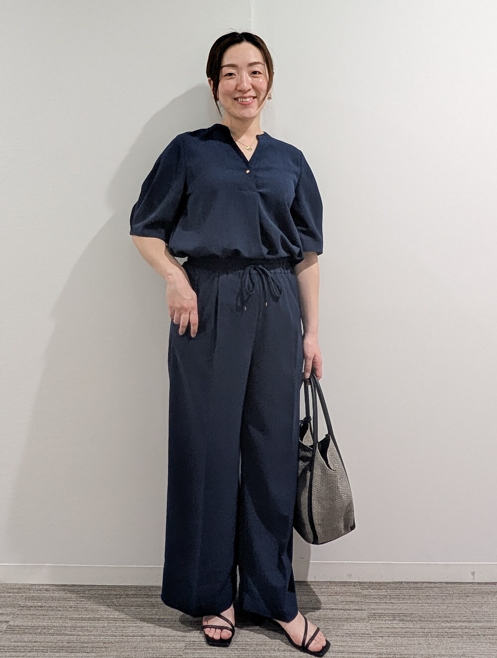 グレー系のシャツ/ブラウス、グレー系のその他パンツ、ブラック系のトートバッグを着用したレディースの春コーディネートの10枚目の写真