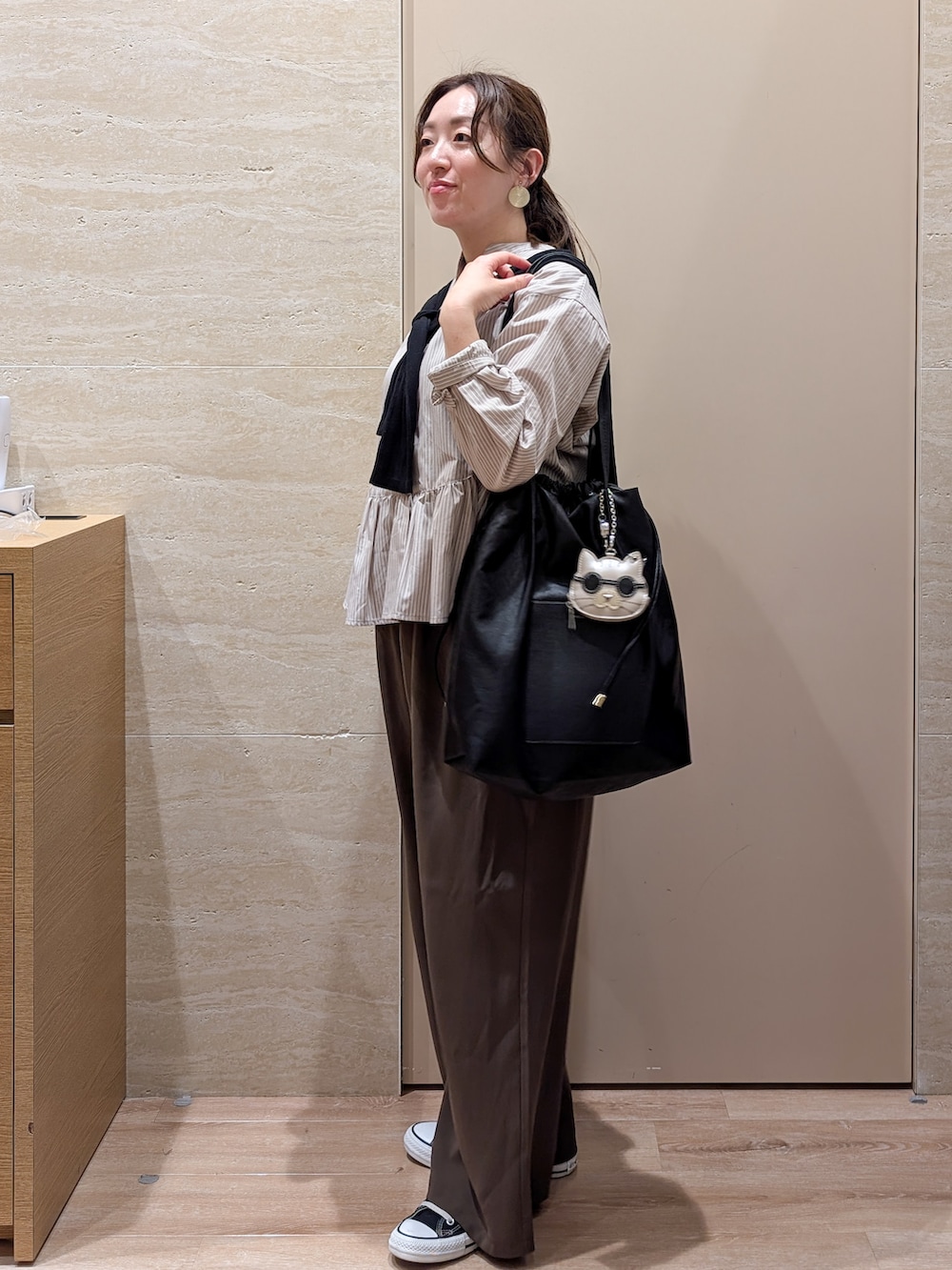 ベージュ系のシャツ/ブラウス、ブラウン系のその他パンツ、ブラック系のトートバッグを着用したレディースの秋コーディネートの2枚目の写真