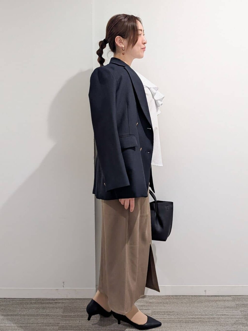 ブルー系のシャツ/ブラウス、ブラック系のパンプス、ブラウン系のスカートを着用したレディースの春コーディネートの6枚目の写真