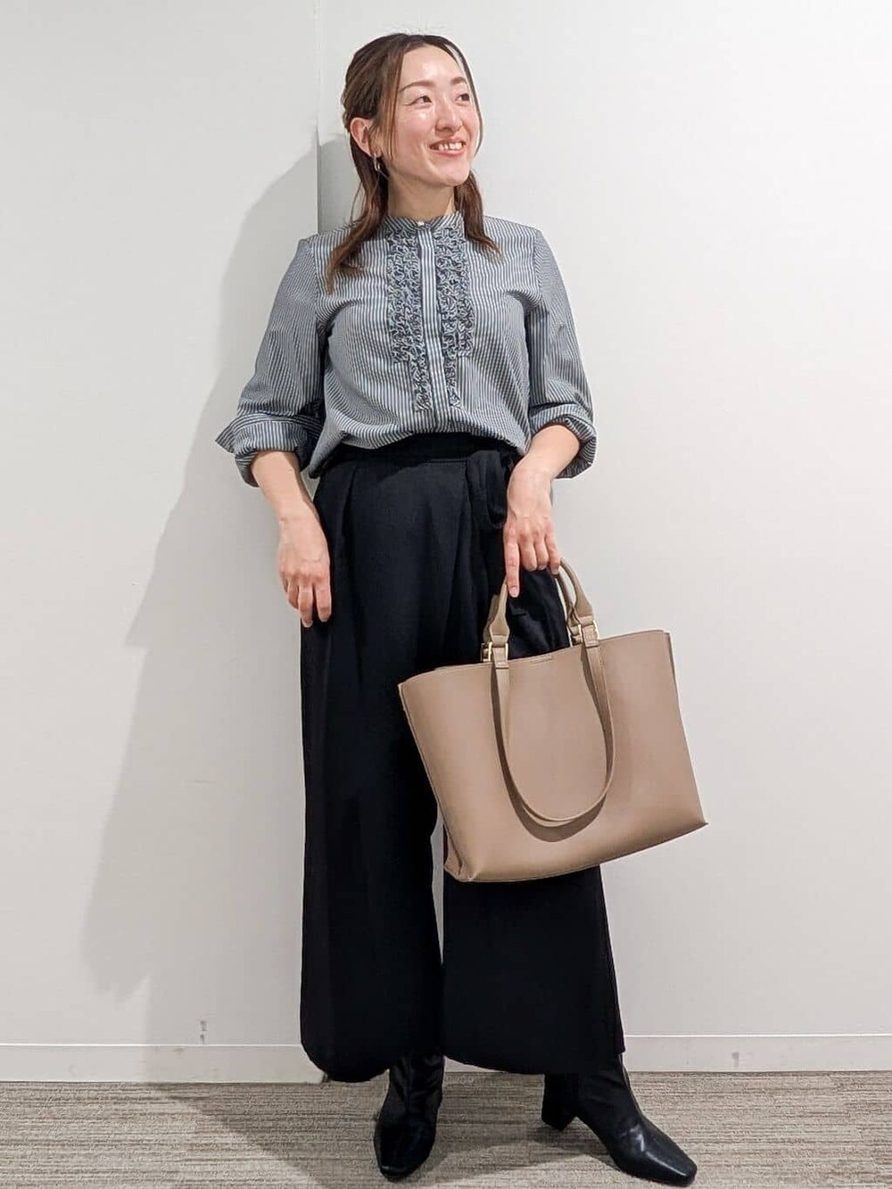 グレー系のシャツ/ブラウス、ブラック系のその他パンツ、ベージュ系のトートバッグを着用したレディースの秋コーディネートの4枚目の写真