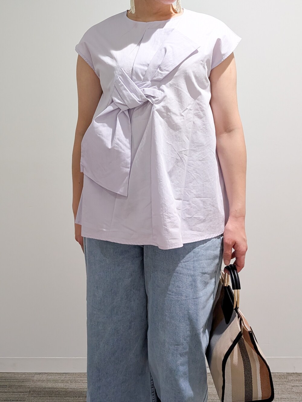 パープル系のシャツ/ブラウス、ブルー系のデニムパンツ、ブラック系のトートバッグを着用したレディースの夏コーディネートの8枚目の写真