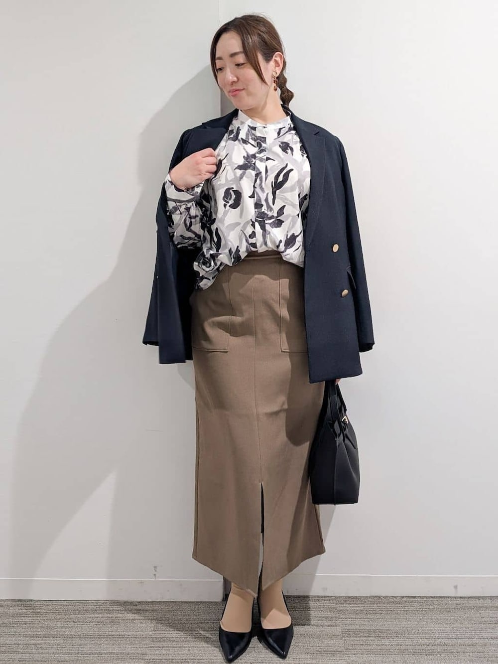 ブラック系のシャツ/ブラウス、ブラウン系のスカート、ブラック系のトートバッグを着用したレディースの春コーディネートの9枚目の写真