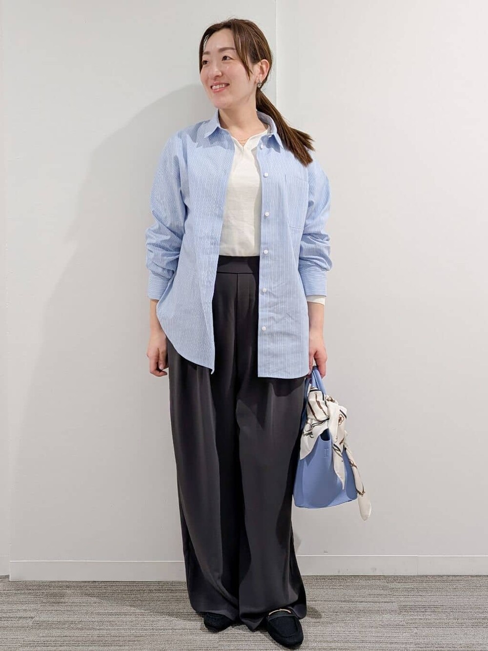 イエロー系のニット/セーター、ブルー系のシャツ/ブラウス、グレー系のその他パンツを着用したレディースの冬コーディネートの9枚目の写真