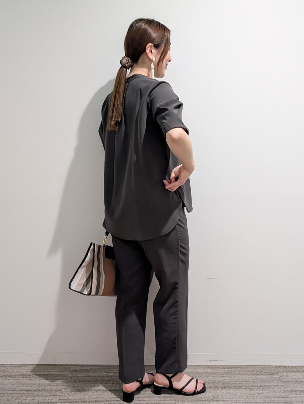 グレー系のシャツ/ブラウス、グレー系のその他パンツ、ブラック系のトートバッグを着用したレディースの春コーディネートの5枚目の写真