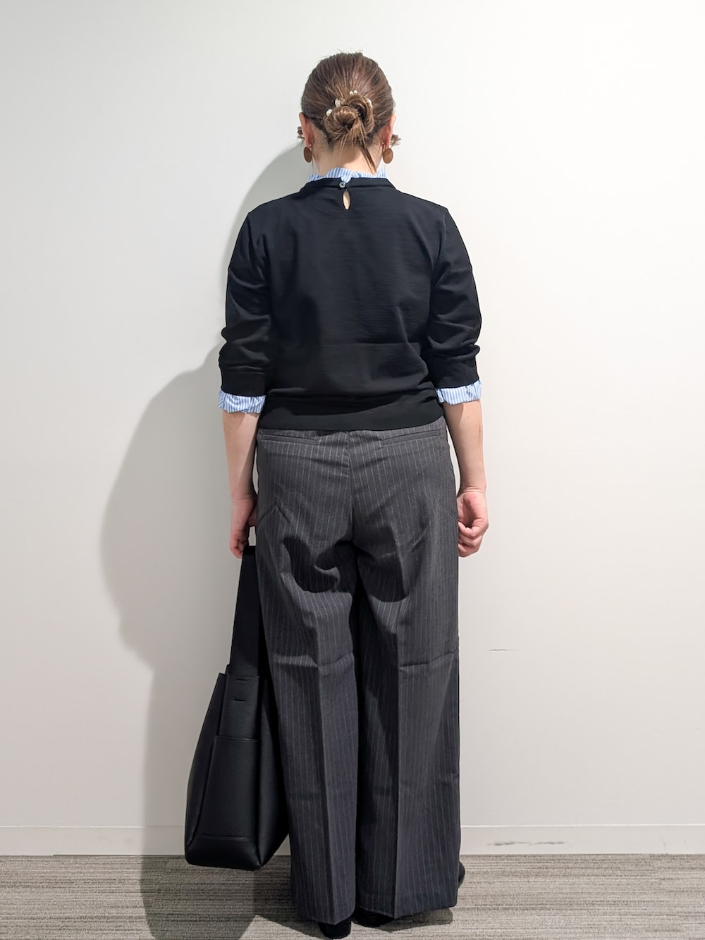 ブラック系のニット/セーター、グレー系のその他パンツ、ブラック系のトートバッグを着用したレディースの秋コーディネートの5枚目の写真