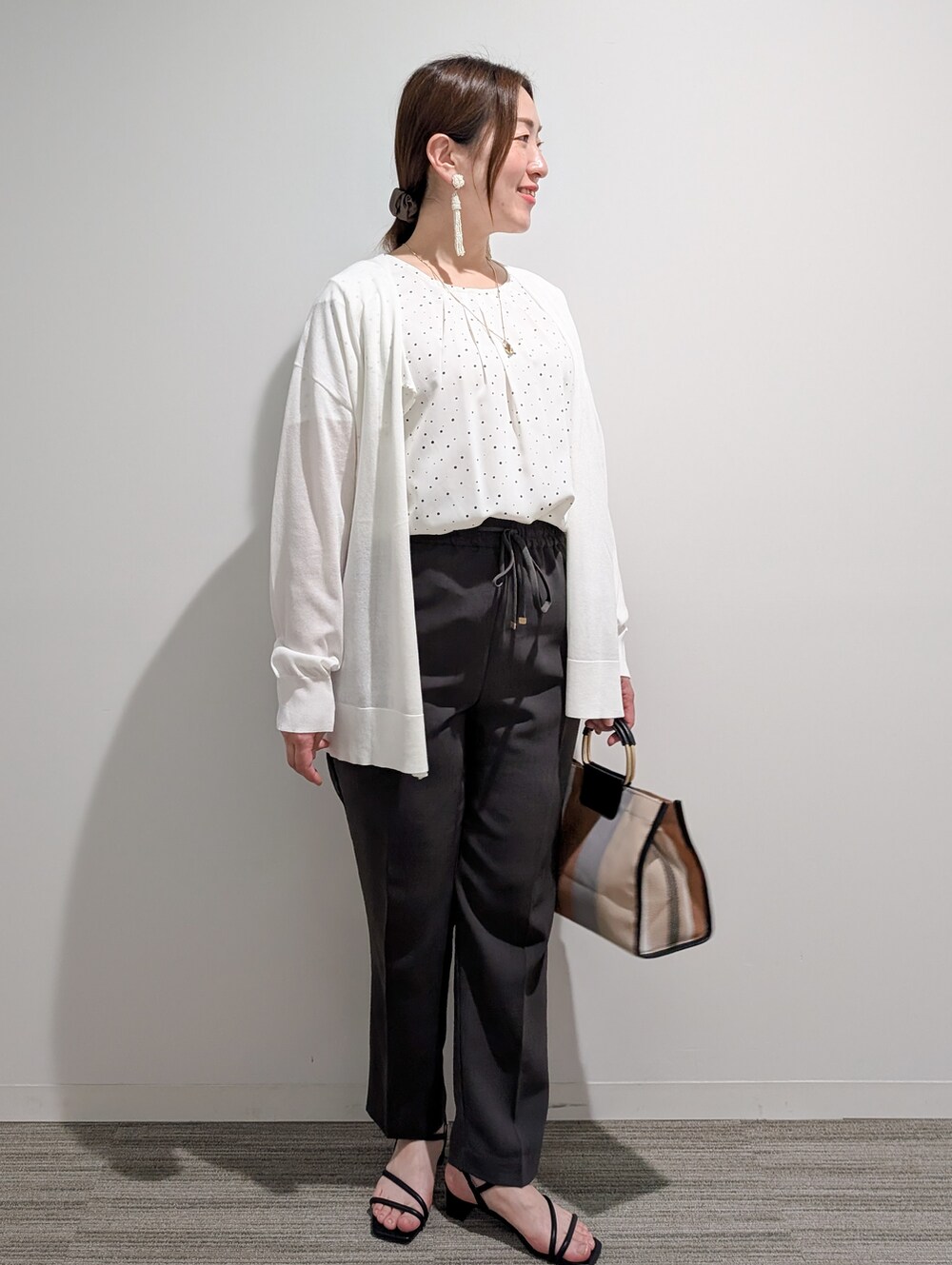 ホワイト系のシャツ/ブラウス、グレー系のその他パンツ、ブラック系のサンダルを着用したレディースの春コーディネートの3枚目の写真