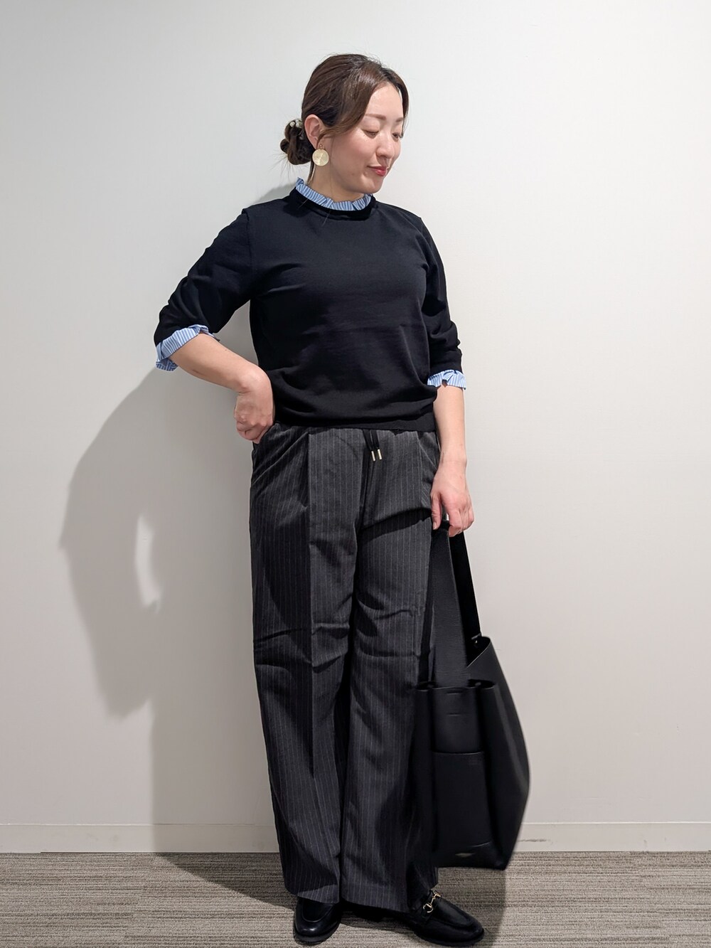 ブラック系のニット/セーター、グレー系のその他パンツ、ブラック系のトートバッグを着用したレディースの秋コーディネートの2枚目の写真