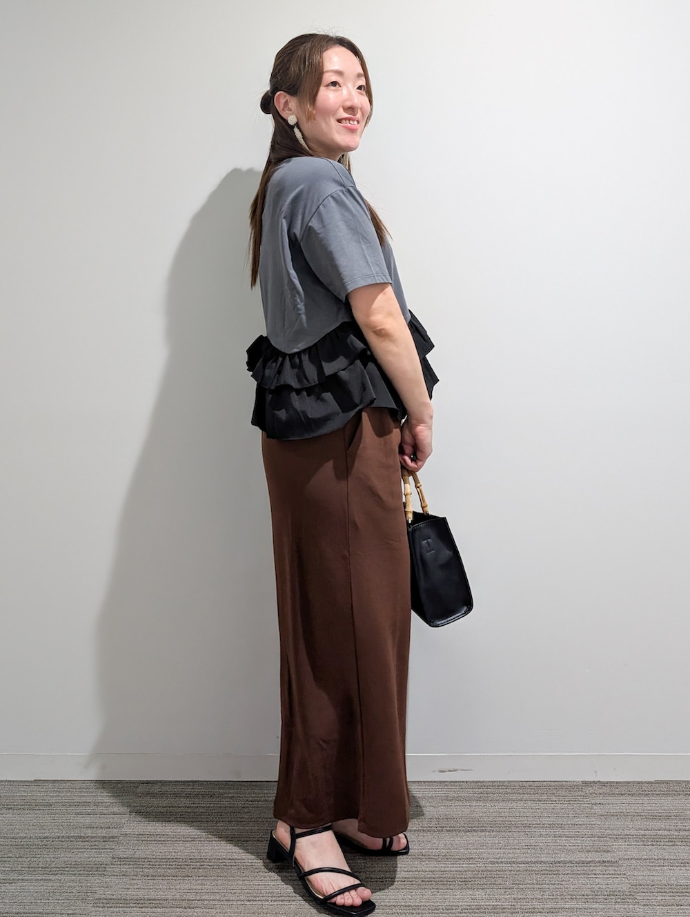 グレー系のTシャツ/カットソー、ブラウン系のスカート、ブラック系のトートバッグを着用したレディースの夏コーディネートの6枚目の写真