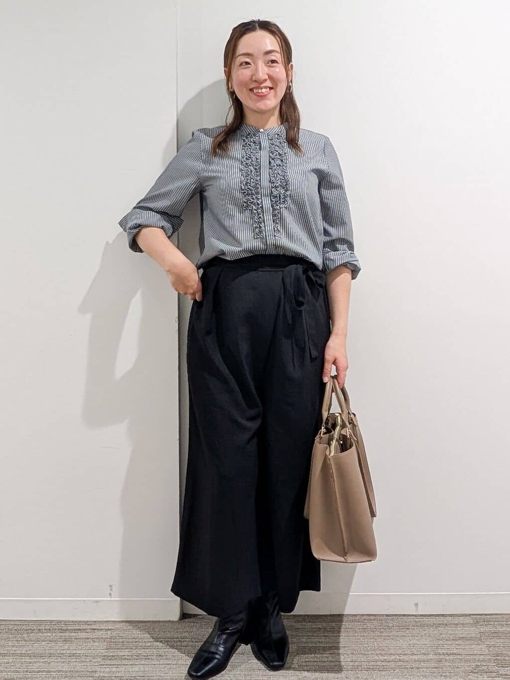 グレー系のシャツ/ブラウス、ブラック系のその他パンツ、ベージュ系のトートバッグを着用したレディースの秋コーディネートの3枚目の写真