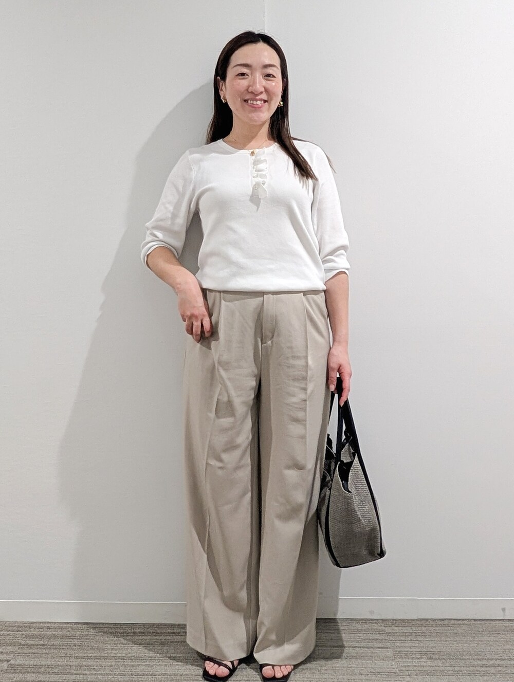ホワイト系のニット/セーター、ベージュ系のその他パンツ、グレー系のトートバッグを着用したレディースの春コーディネートの3枚目の写真