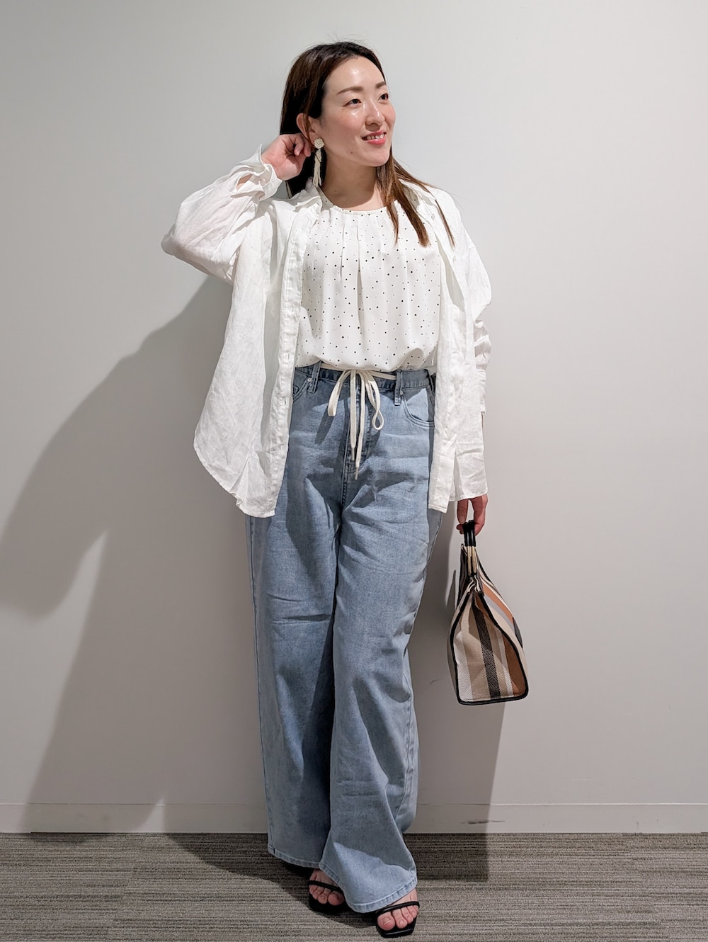 ホワイト系のシャツ/ブラウス、ホワイト系のシャツ/ブラウス、ブラック系のサンダルを着用したレディースの春コーディネートの3枚目の写真