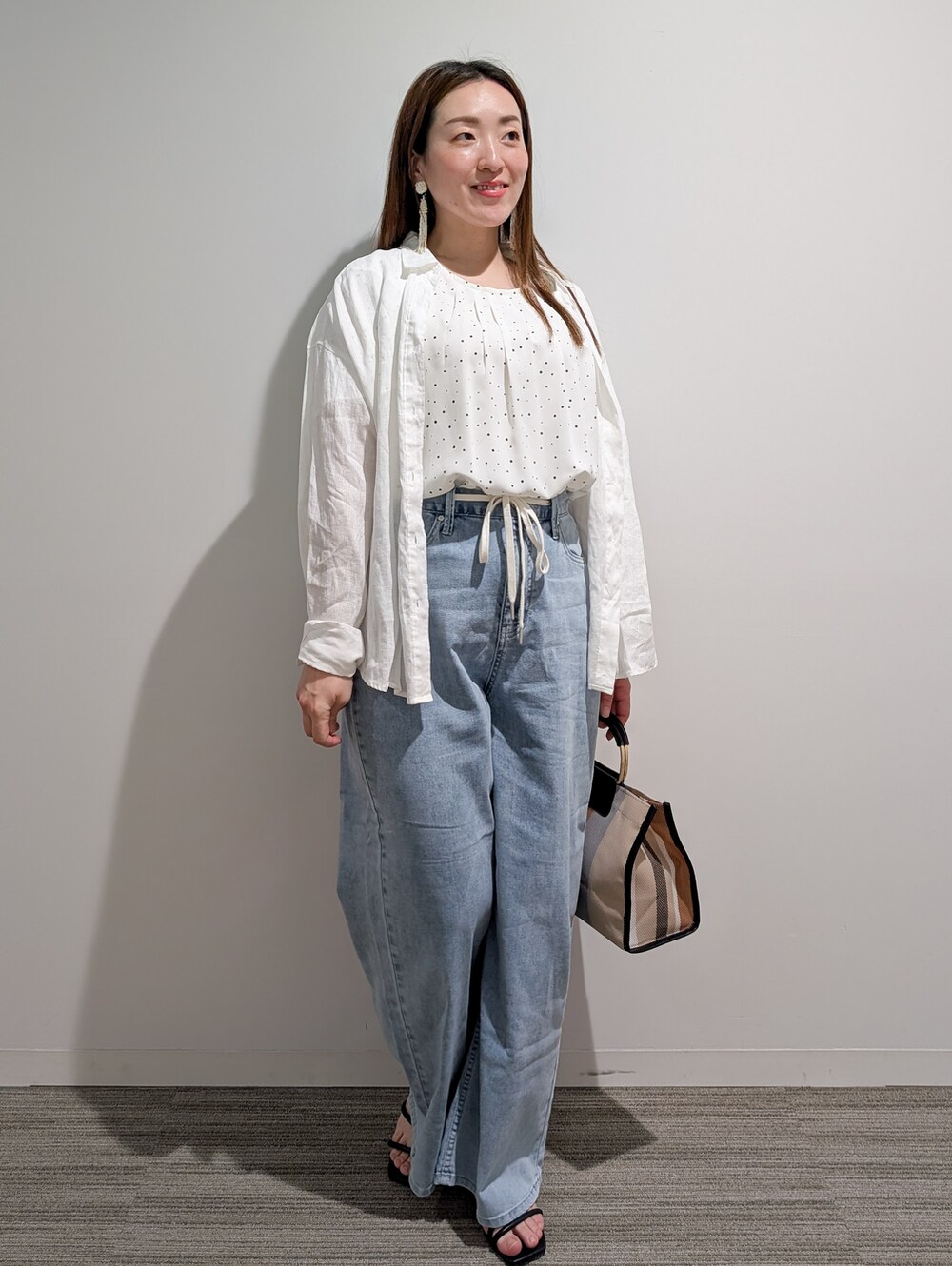 ホワイト系のシャツ/ブラウス、ホワイト系のシャツ/ブラウス、ブラック系のサンダルを着用したレディースの春コーディネートの2枚目の写真