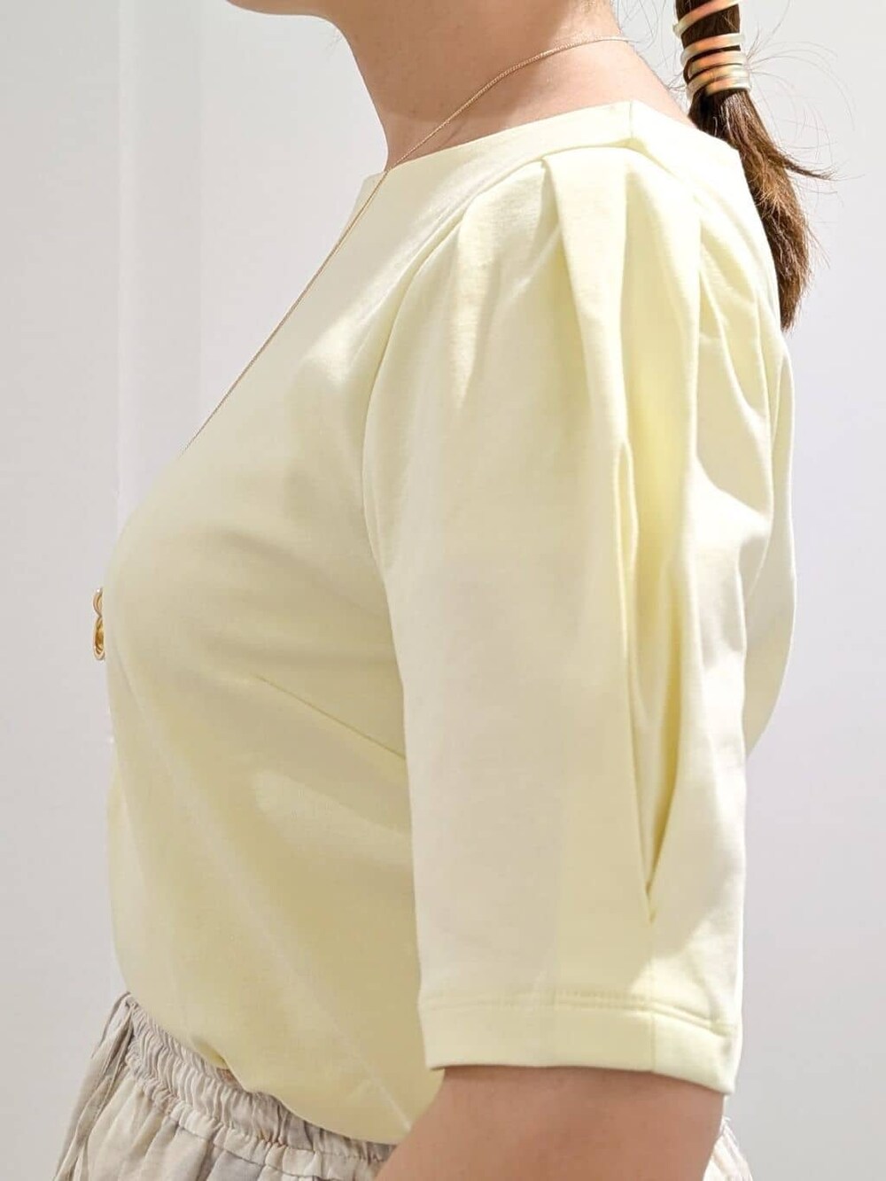 イエロー系のTシャツ/カットソー、グレー系のその他パンツ、ブラック系のハンドバッグを着用したレディースの夏コーディネートの8枚目の写真