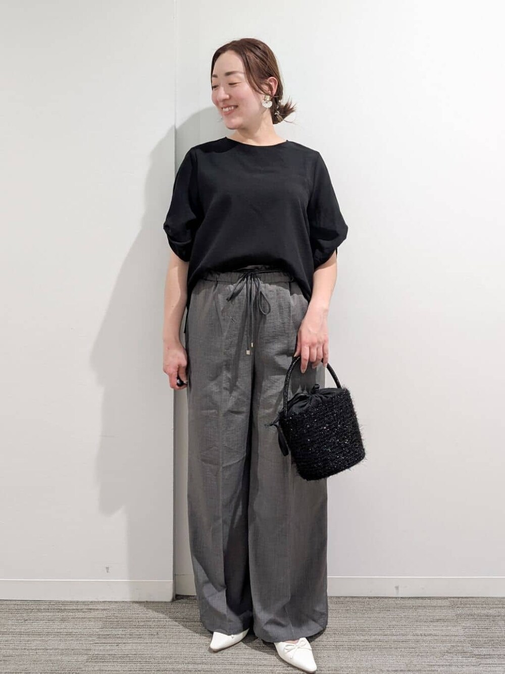 ブラック系のシャツ/ブラウス、グレー系のその他パンツ、ブラック系のハンドバッグを着用したレディースの夏コーディネートの2枚目の写真