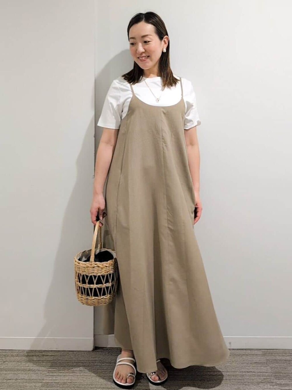 ブラック系のニット/セーター、ベージュ系のワンピース、ブルー系のトートバッグを着用したレディースの夏コーディネートの9枚目の写真