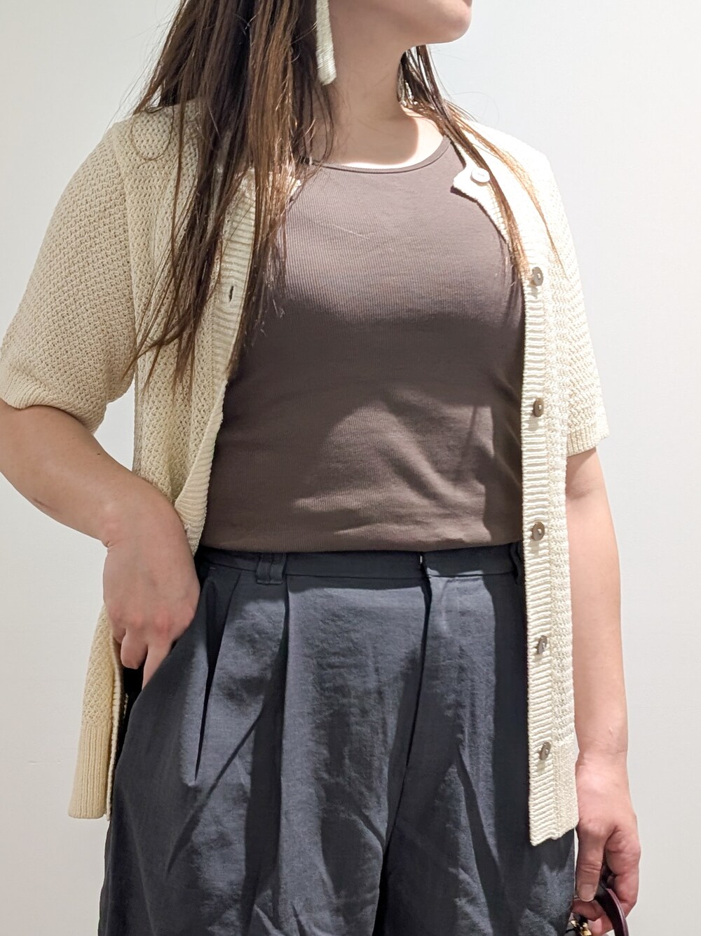 ホワイト系のカーディガン/ボレロ、ブラウン系のタンクトップ、グレー系のその他パンツを着用したレディースの秋コーディネートの9枚目の写真