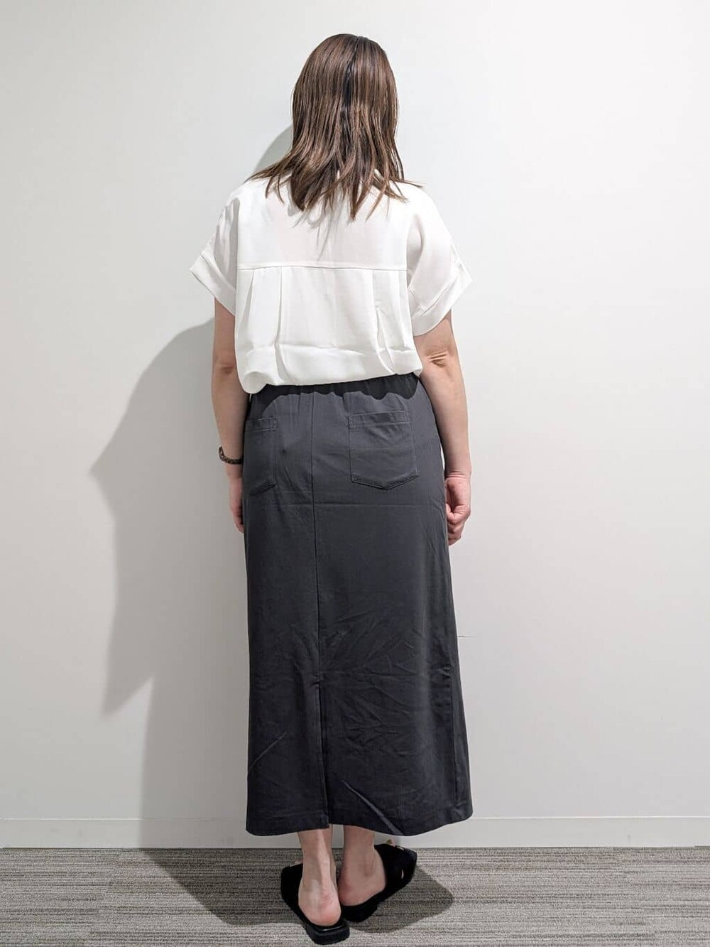 ホワイト系のシャツ/ブラウス、グレー系のスカート、ブラック系のサンダルを着用したレディースの夏コーディネートの6枚目の写真
