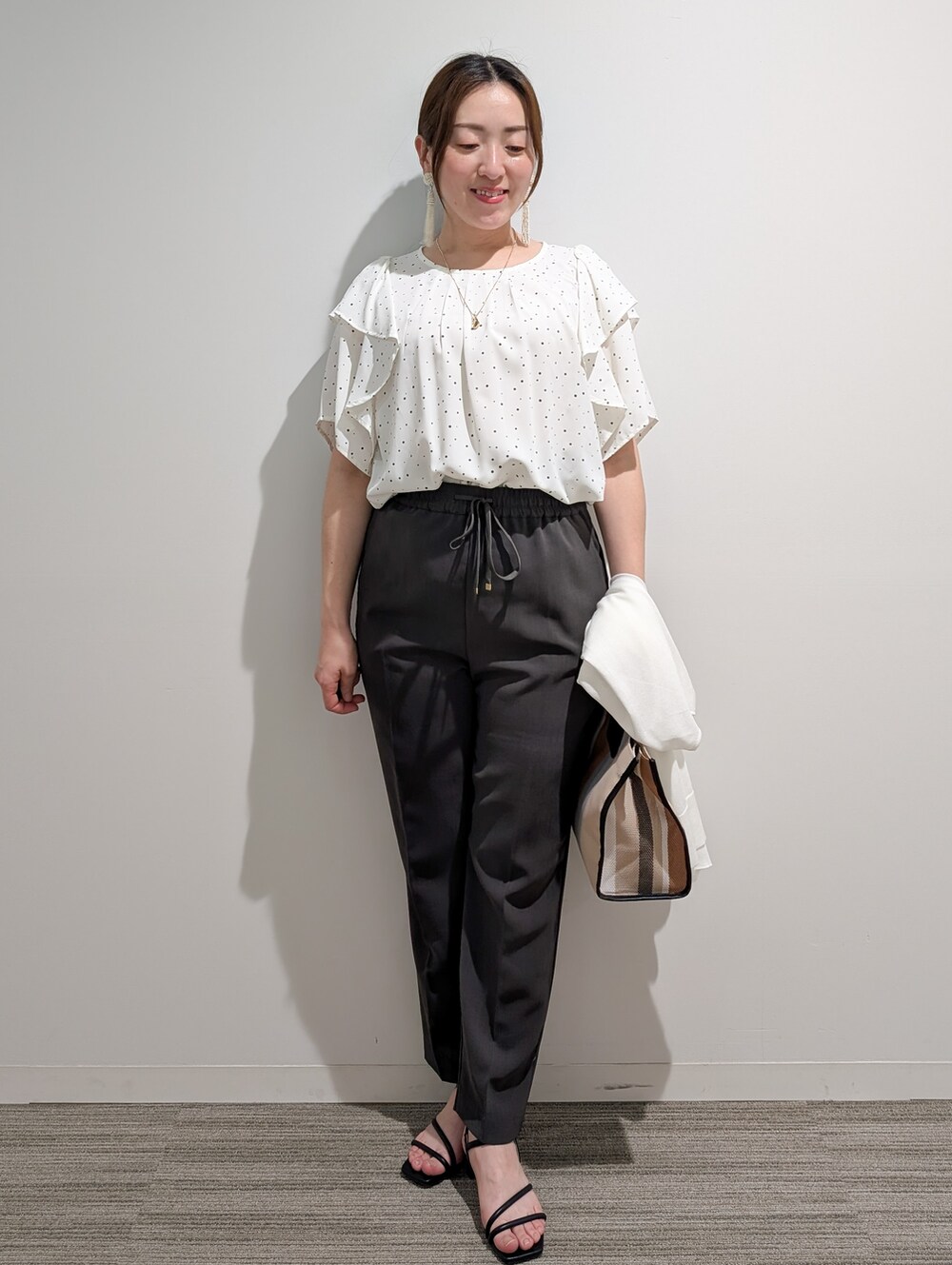 ホワイト系のシャツ/ブラウス、グレー系のその他パンツ、ブラック系のサンダルを着用したレディースの春コーディネートの7枚目の写真